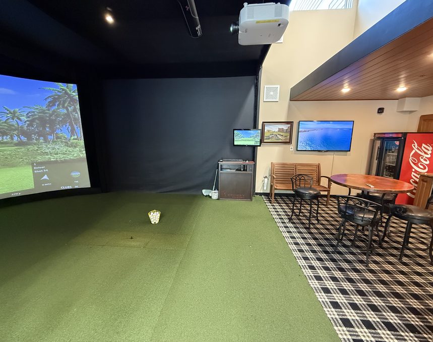 Inside the 3,200 square foot unit: a golf simulator with curved screen, table seating and a bar area